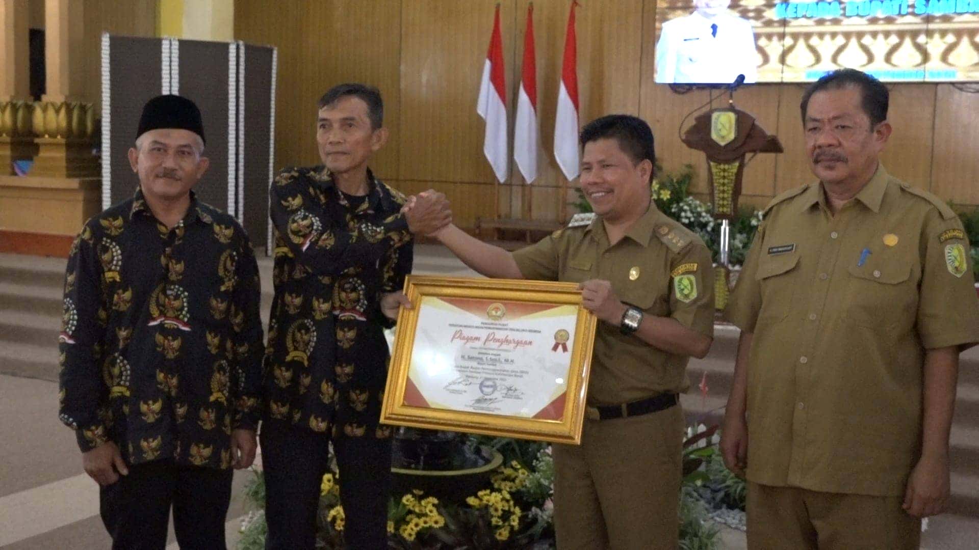 DITANDA TANGANI RIDWAN KAMIL, BUPATI SATONO TERIMA PIAGAM PENGHARGAAN DARI ABPEDSI KAB. SAMBAS